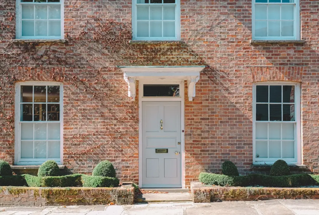 A white panelled front door set into a brick facade.